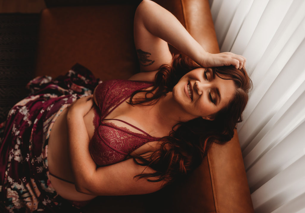 Rocklin boudoir session with purple lingerie on couch at Limitless Boudoir near Sacramento
